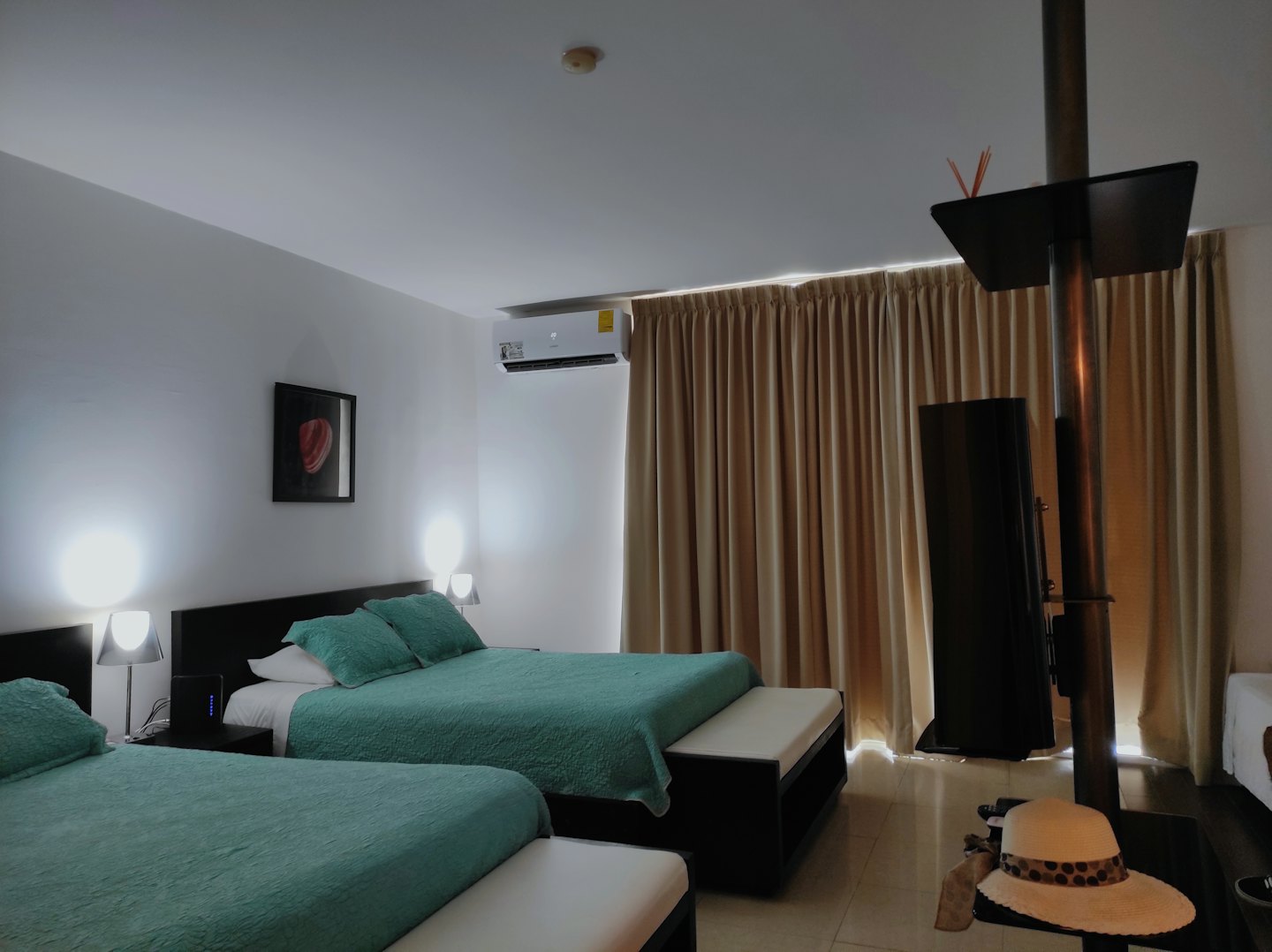 Camera d'albergo moderna con due letti e biancheria da letto color ottanio.